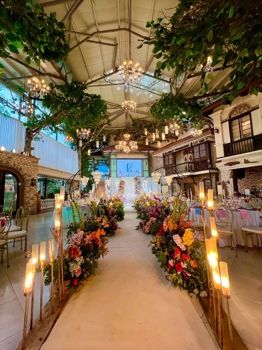 A candlelit floral aisle at dusk, styled for a GO Events wedding reception.