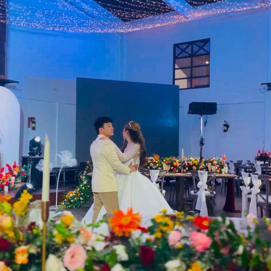 A couple's first dance lit in colorful reception lighting, at a GO Events wedding.