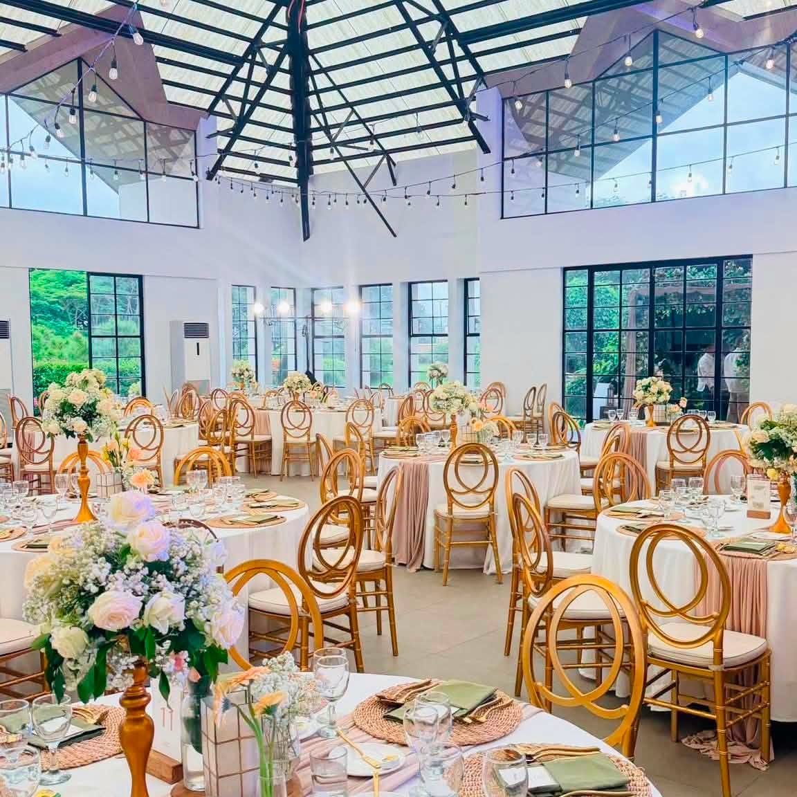 A reception hall set with gold chiavari chairs and florals, styled for a GO Events wedding.